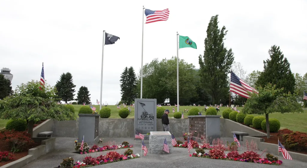 POW MIA Plaza at Washington Memorial Park, flags waving against lush green background.